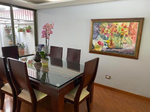 une table à manger avec des chaises et un tableau mural dans l'établissement CHARLIE'S HOUSE, à Bogotá