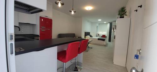 een keuken met een zwarte bar en rode kasten bij Loft A la verita River,PARKING FREE,DIRECT ACCESS ,SIN ESCALONES in Córdoba