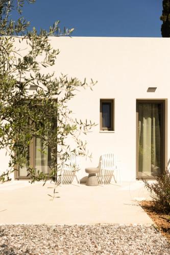 a white house with two chairs on a patio at Stablo Residence in Kanálion