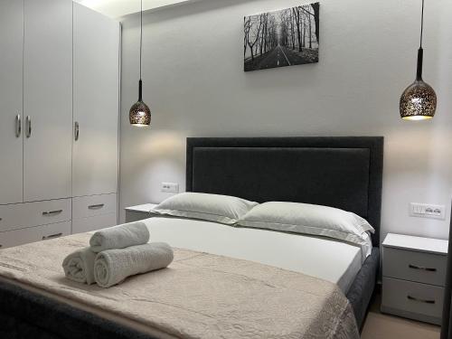 a bedroom with a bed with two towels on it at Lorenso Guest House in Sarandë