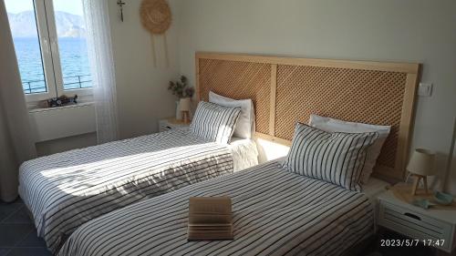 a bedroom with two beds and a window at Aegean Villita on beach apartment in Kalymnos