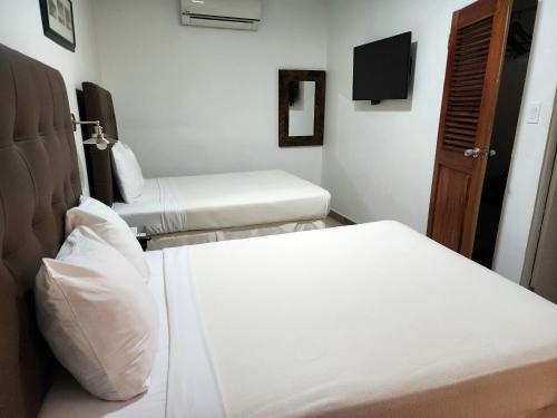 a hotel room with two beds and a tv at Altamont West Hotel in Montego Bay