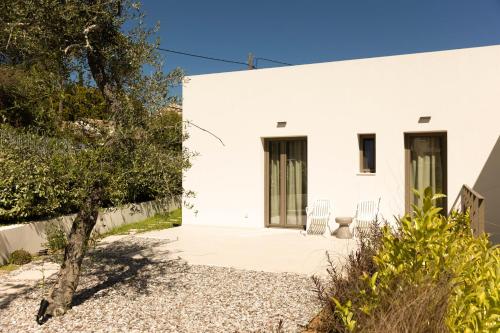 a white house with two chairs on a patio at Stablo Residence in Kanálion