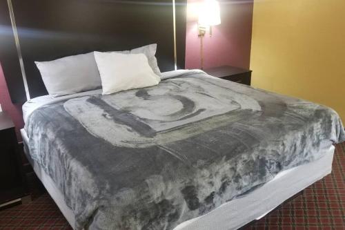 a bed with a painting of a man on it at Hotel 2 Queen Beds Hotel Room 208 Wi-Fi Room Booking in Stillwater