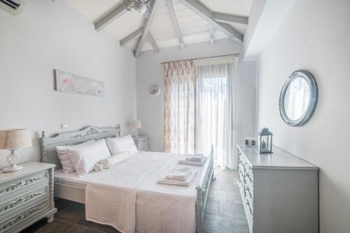 a bedroom with a bed and a dresser and a window at Green Garden in Porto Heli