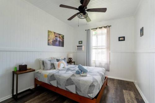 a bedroom with a bed with a ceiling fan at Somewhere over the Rainbow Loft with AC Hilo in Hilo