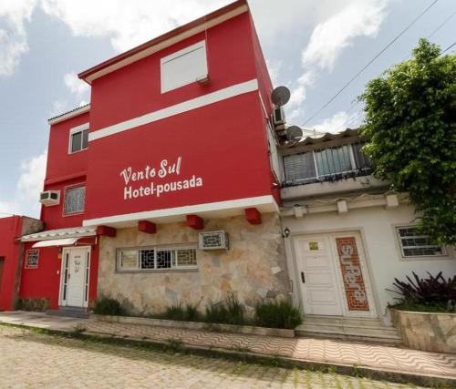 um edifício vermelho com as palavras que ainda está no hotel requisitado em Hotel Pousada Vento Sul em Rio Grande