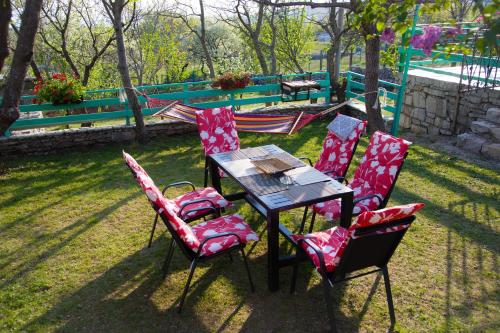 a table and four chairs in a yard at Vila Agroturizam Kućica Mostar-Welcome bikers in Mostar