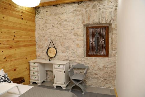 a room with a desk and a stone wall at LAKE HOUSE 'VILIN KONAK' in Nikšić