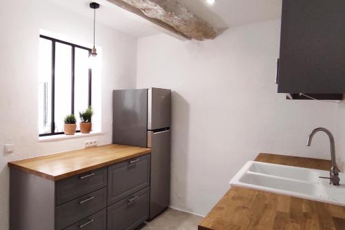 une cuisine avec un réfrigérateur en acier inoxydable et un évier dans l'établissement Mas d'Alauré, à Verquières