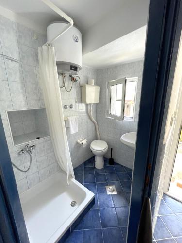 a bathroom with a tub and a toilet and a sink at APARTMENT NUNA in Baška