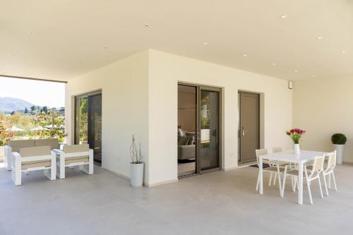a white dining room with a table and chairs at Stablo Residence in Kanálion