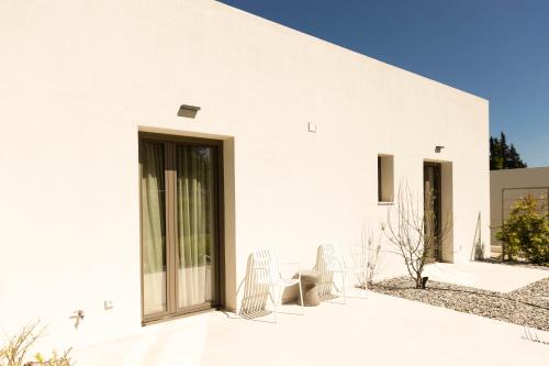 a white house with chairs on a patio at Stablo Residence in Kanálion