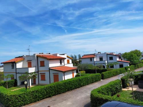 una fila de casas blancas con techos rojos en una calle en stella marina, en Porto Recanati