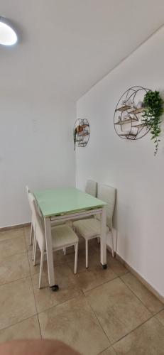 a dining room table with chairs and a green table at דירת נופש במרכז טבריה in Tiberias
