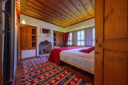 a bedroom with a large bed and a fireplace at Şerbetçi Garden Konak in Safranbolu