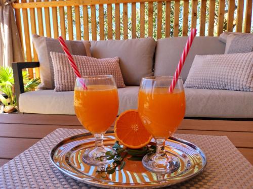 two glasses of orange juice on a tray on a table at Zen Zone Premium Mobile Home in Drage