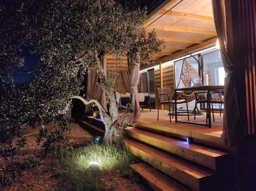 a house with a tree on a wooden porch at Zen Zone Premium Mobile Home in Drage
