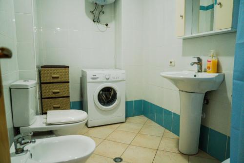 een badkamer met een wasmachine en een wastafel bij Apartament Casas del Mar in Durrës