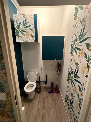 a small bathroom with a toilet and a tv at Charment Appartement T3 Palaiseau Camille Claudel in Palaiseau