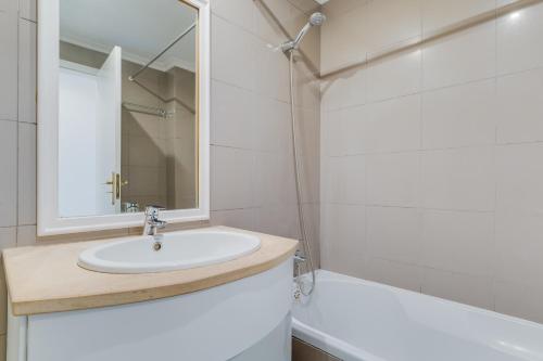 La salle de bains est pourvue d'un lavabo, d'un miroir et d'une baignoire. dans l'établissement Bela São Tiago I, à Funchal