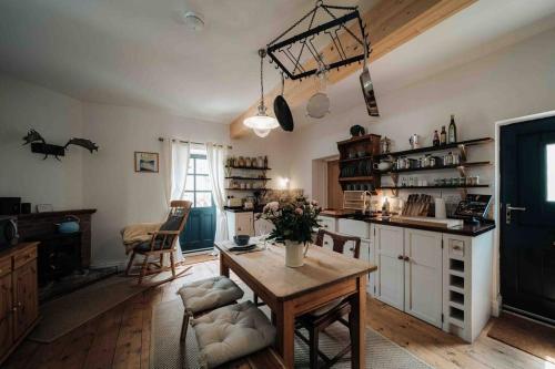 a kitchen with a wooden table and a kitchen with a dining room at Roxie House a cosy farm refurbished Coach House. in Gittisham