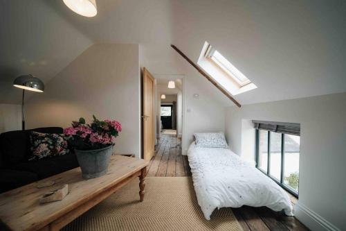 a living room with a bed and a couch at Roxie House a cosy farm refurbished Coach House. in Gittisham