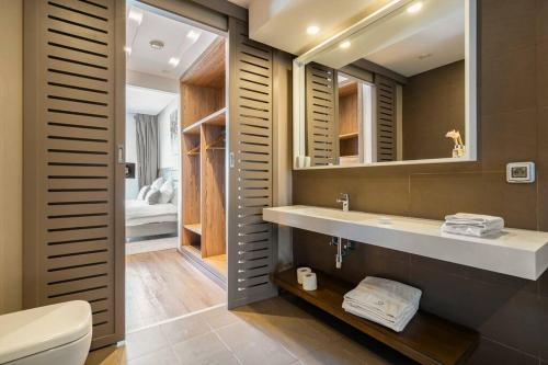 a bathroom with a sink and a toilet and a mirror at Sublime Appart sur la Corniche , Luxueux et Vue sur Mer in Casablanca