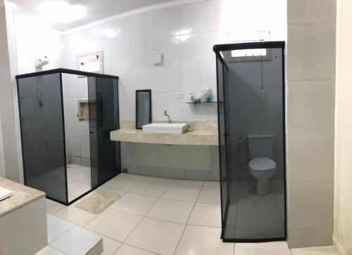 uma casa de banho com um chuveiro, um lavatório e um WC. em Propriedade sinta-se em casa em Piranhas