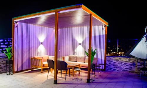a gazebo with a couch on a patio at night at Johen Residence in Douala