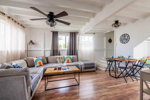 a living room with a couch and a ceiling fan at Somewhere over the Rainbow Loft with AC Hilo in Hilo