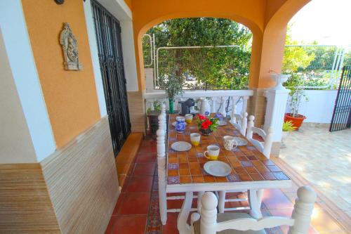 a table and chairs sitting on a porch with a table at Great villa, Sea views, 20 secs walk to the beach, BBQ, 9 people, 5 mins car from Alicante city center, sailing club 3 mins walk in Alicante