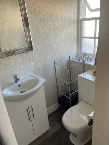 a bathroom with a sink and a toilet and a mirror at Bells Yard cottage in Maryport