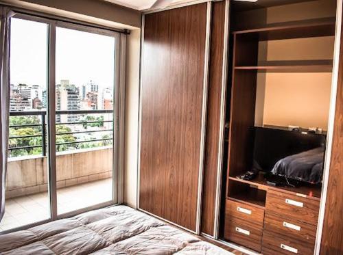 サン・ミゲル・デ・トゥクマンにあるMIRADOR PANORAMICO-DEPTO TUCUMANのベッドルーム1室(ベッド1台、大きなガラス窓付)