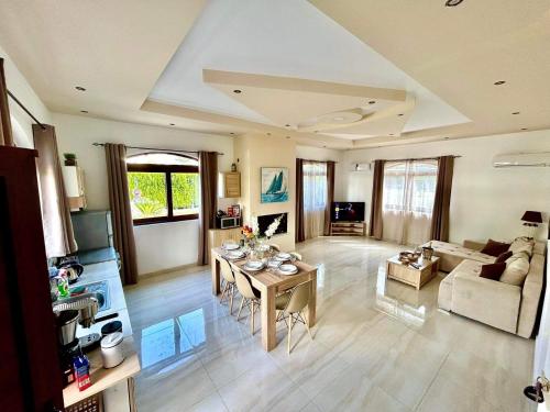 uma grande sala de estar com uma mesa e um sofá em Nicole Luxury Villas em Koskinou