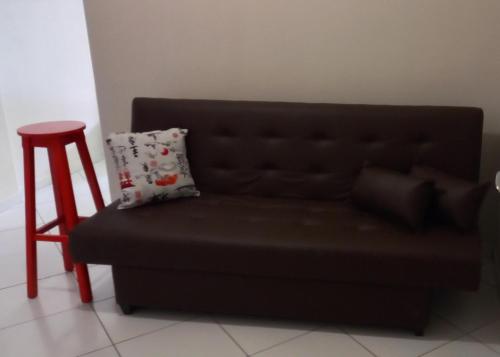 a black couch with a stool next to a table at Ap no melhor lugar do Centro com elevador, wi-fi e Smart TV in Vitória