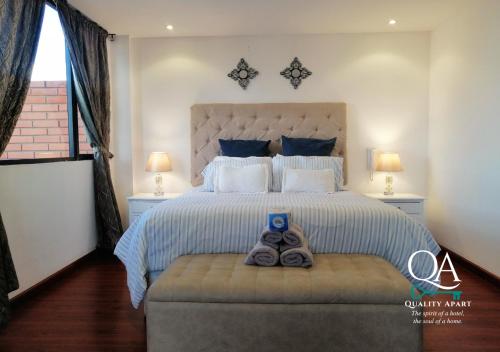 a bedroom with a large bed with a pair of shoes at Quality Apart, Exclusive Penthouses in Cuenca