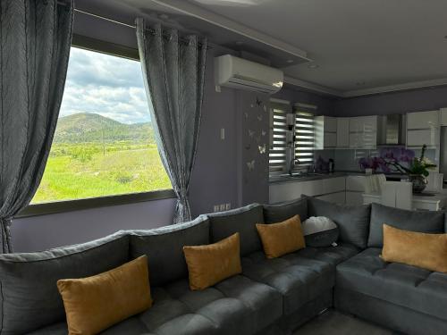 a living room with a couch and a large window at Villa Klajdi in Përmet