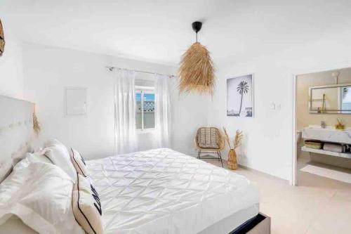 - une chambre blanche avec un lit et une chaise dans l'établissement The Bay at Palm Beach, Simpson Bay, à Simpson Bay