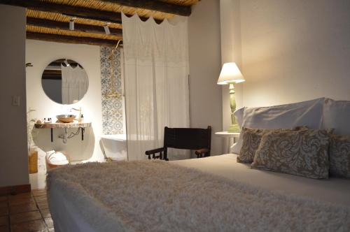a bedroom with a bed and a table and a chair at Hotel Casa Boutique Villa de Leyva in Villa de Leyva
