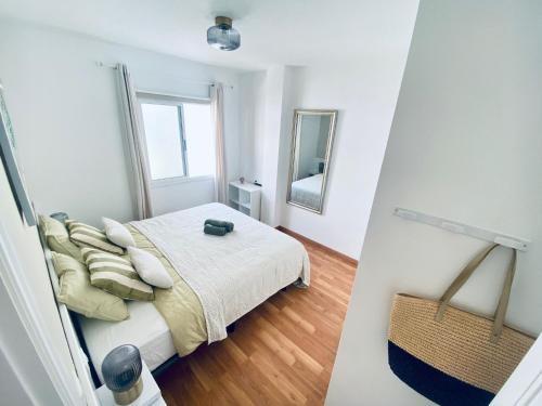 Habitación blanca con cama y espejo en MÉDANO LOVER By TOP STAY, en El Médano