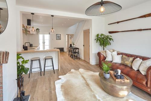 sala de estar con sofá marrón y cocina en Boutique Fisherman’s Cottage, en Cullercoats