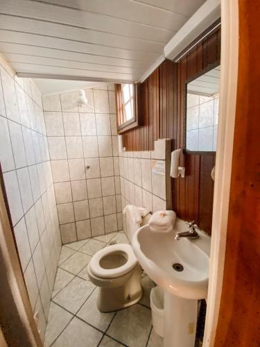 a small bathroom with a toilet and a sink at Villa'l Mare Hotel in Maresias