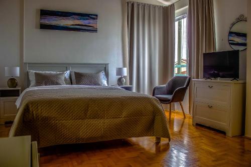 a bedroom with a bed and a television and a chair at Apartman Tramontana in Opatija
