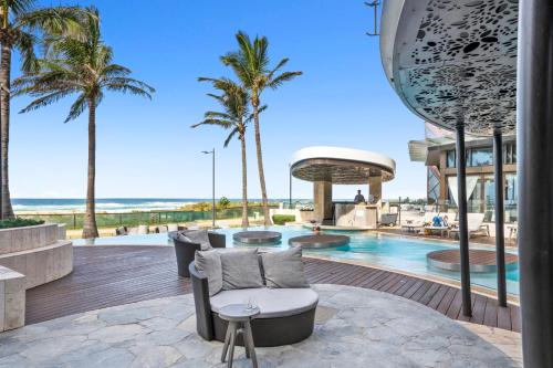 黃金海岸的住宿－Jewel Beachfront Residences，享有带游泳池和棕榈树的度假村的景致