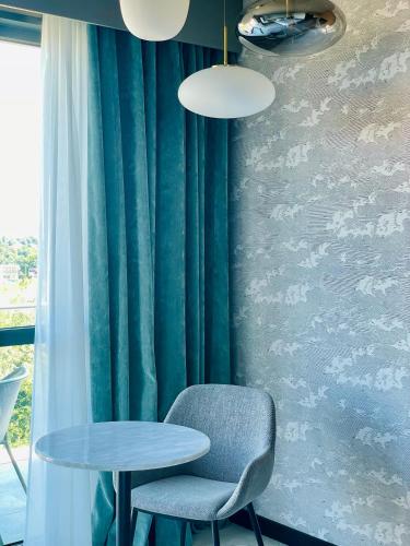 a table and a chair next to a window at KYRIAD LYON OUEST Limonest in Limonest