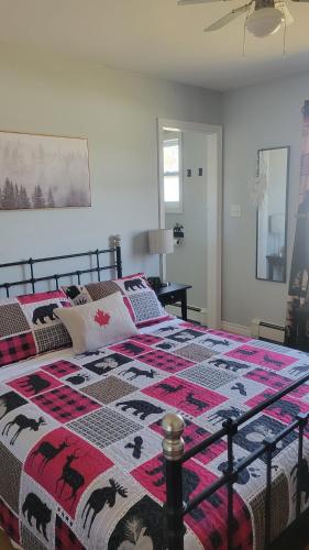 a bedroom with a bed with a quilt on it at Bryson's Bed and Breakfast in Baddeck