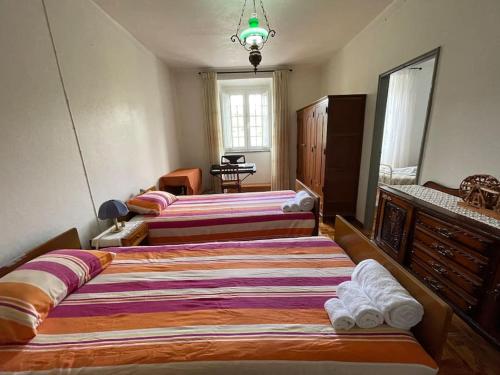 a bedroom with two beds and a dresser at Casa da Celeste in Maljoga de Proença
