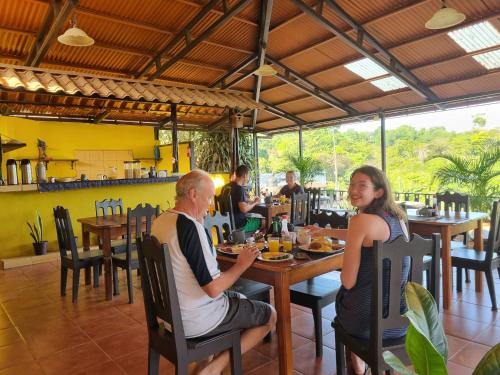 a man and woman sitting at a table in a restaurant at Cabinas Pura Vida B&B and Tour Operator in Drake