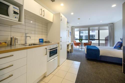 a kitchen and a bedroom with a bed and a sink at U Residence Hotel in Wellington